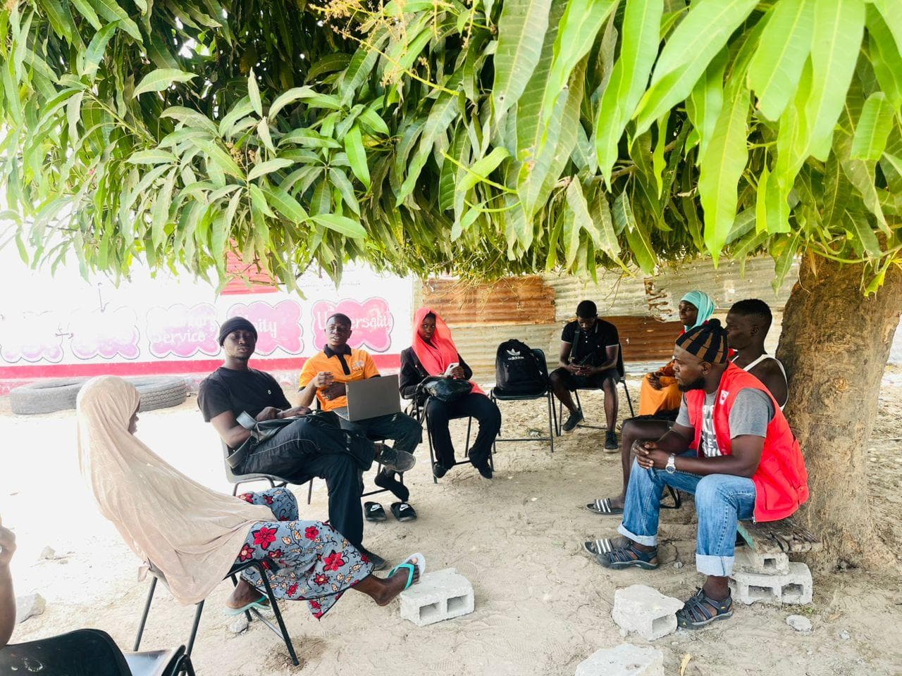 Young people at an SMF skills workshop held outdoors in The Gambia